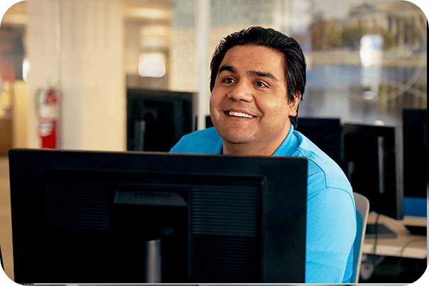 smiling man in front of a computer screen